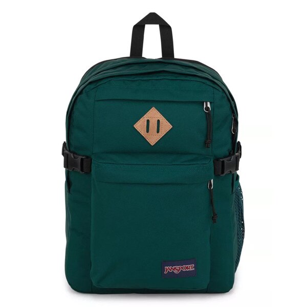 A dark green jansport backpack with two front pockets and two main compartments, with side mesh pockets, shoulder straps, and a top strap to hold.